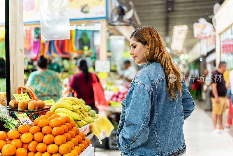 Young woman looking around while walking through the market